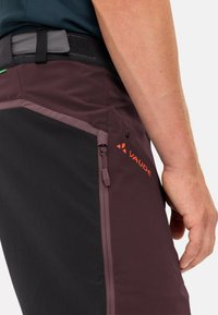 Pantaloni corti da trekking in bordeaux e nero con tasca con zip, realizzati in tessuto resistente. Presentano una chiusura in Velcro in vita e cuciture a contrasto.