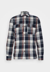 Rutigt flanellskjorta i marinblått, vitt och rött; har knäppning framtill, två bröstfickor och långa ärmar med knäppning vid handlederna.