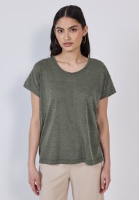 T-shirt verde oliva a maniche corte realizzato in morbido tessuto con scollatura rotonda e vestibilità rilassata, con risvolti sulle maniche e orlo dritto.