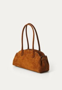 Borsa in suede marrone con due manici lunghi, forma arrotondata, texture liscia e dettagli di cucitura sottili lungo i bordi.