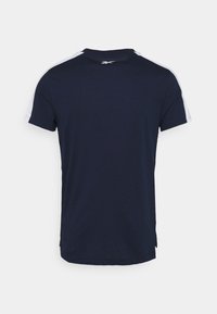 Marinblå sportströja med korta ärmar och vita detaljer, rundad halsringning och mjuk bomullstextur. Visad bakifrån.