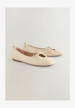 Beige ballerinaer med rundet tå, lille sløjfedetalje og lav, flad sål. Glat tekstur med minimalistisk design.