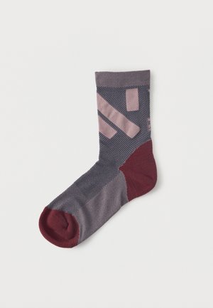 Ein einzelner grauer Socken mit kastanienbrauner Spitze und Ferse, der hellrosa geometrische Formen im Bereich des Knöchels und des Fußes aufweist.