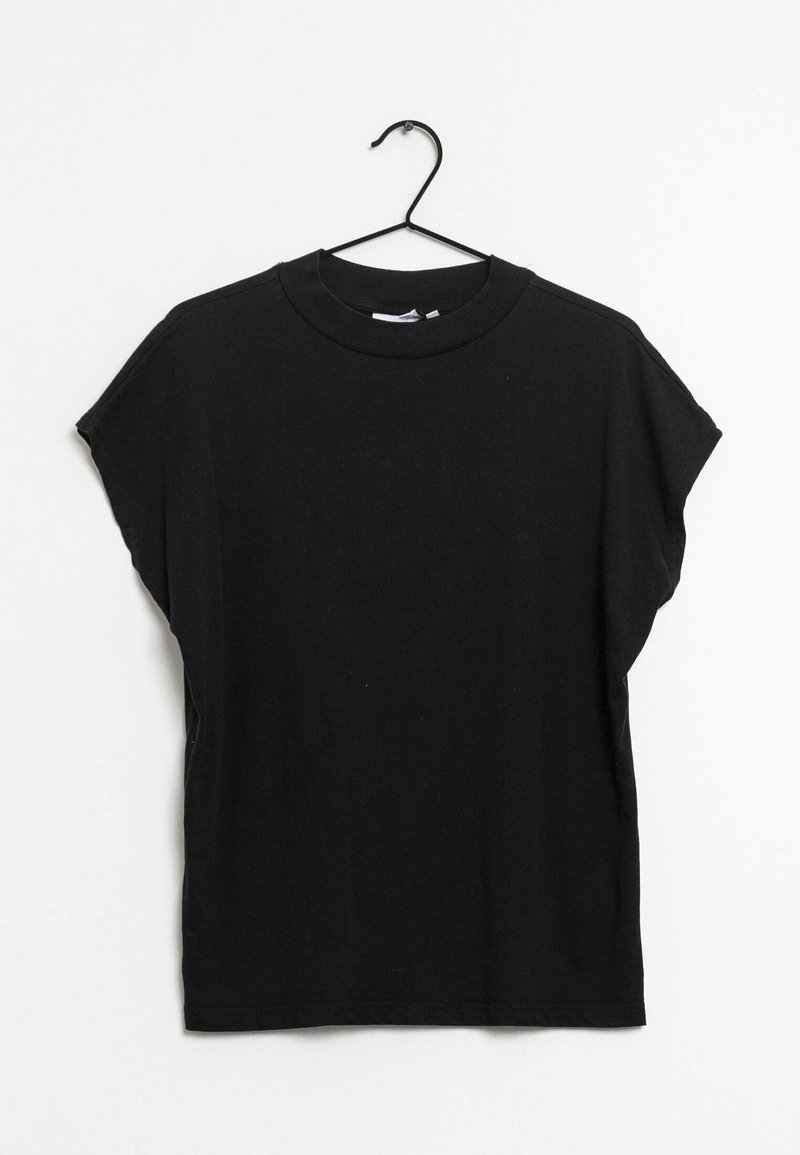 T-shirt noir à manches courtes et col rond suspendu sur un cintre en fil noir sur fond blanc.