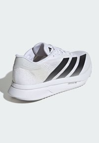 Fehér sportcipő, könnyű hálós felsőrésszel, fekete díszítésekkel, három csíkkal és szürke részletekkel. Könnyű talppal rendelkezik a teljesítmény érdekében.