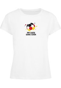 Hvit t-skjorte med grafikk av en fotball i svart, rødt og gult med sprutdetaljer. Teksten sier "WIR SAGEN DANKE SCHÖN."