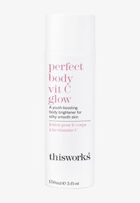 Bouteille de lotion cylindrique blanche avec un bouchon pompe. Texte en rose : "perfect body vit C glow" et "thisworks." Volume : 150 ml.