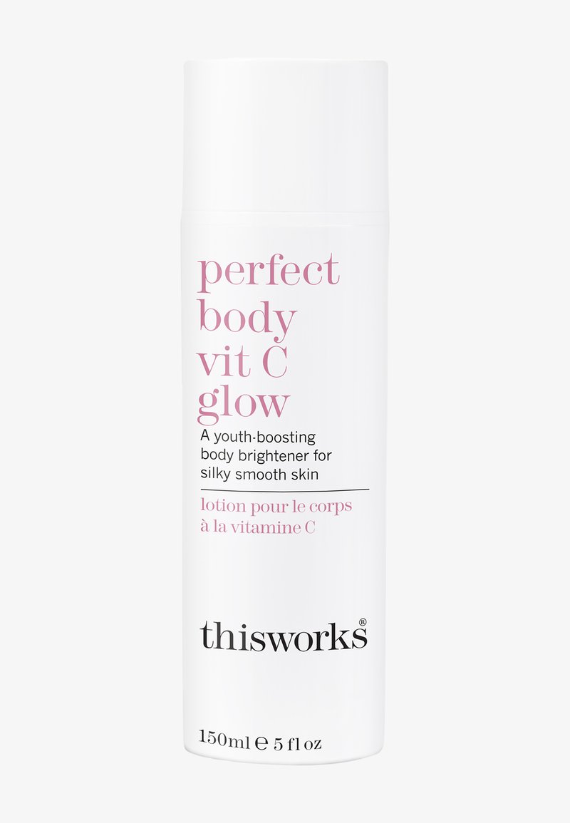 Bouteille de lotion cylindrique blanche avec un bouchon pompe. Texte en rose : "perfect body vit C glow" et "thisworks." Volume : 150 ml.
