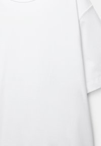 Cămașă albă din bumbac, cu decolteu rotund, mâneci scurte și o textură netedă. Prezintă cusături simple la tiv, fără modele sau accente.