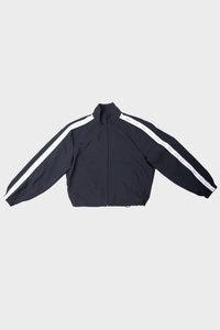 Chaqueta de cremallera azul marino con cuello alto, con rayas blancas en las mangas y puños elásticos. Tejido suave, corte relajado.
