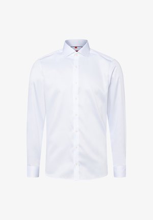 Camicia bianca a maniche lunghe realizzata in tessuto morbido, con colletto classico, chiusura frontale con bottoni e orlo arrotondato.