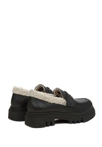 Zwarte leren schoenen met een gestructureerd oppervlak, voorzien van een crèmekleurige nepbont kraag en een robuuste, geribbelde zwarte rubberen zool.