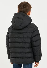 Chaqueta de plumas negra con capucha, que presenta secciones acolchadas horizontales. El material parece suave y ligero, diseñado para proporcionar calor.