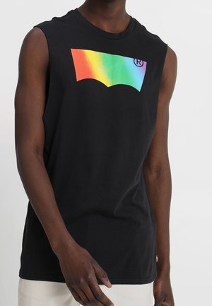 Débardeur noir avec un logo Levi's aux couleurs de l'arc-en-ciel porté par une personne à la peau foncée, visible de l'épaule à la taille.