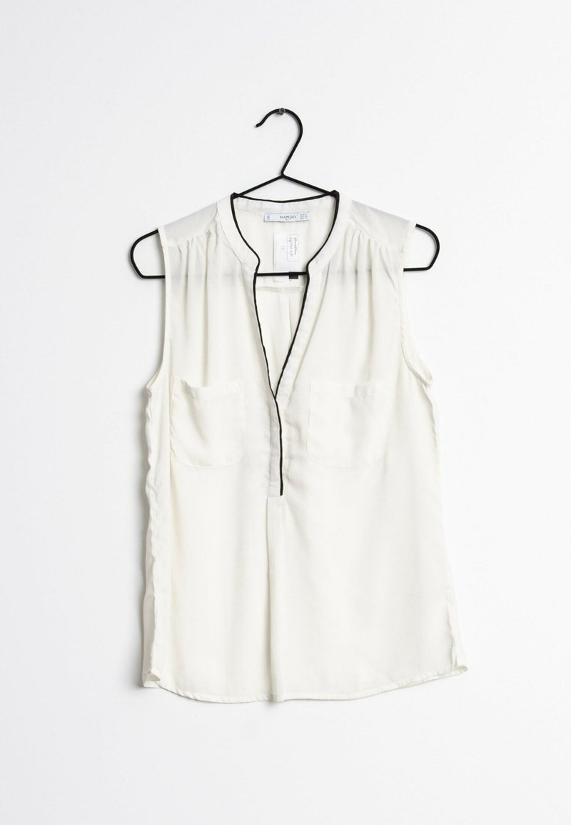 Sleeveless, cream blouse with a V-neck and black trim. Features two chest pockets and a lightweight, smooth texture. Hangs from a black hook.