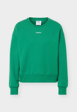 Bluză verde cu mâneci lungi și guler rotund, cu manșete și tiv striate, având un mic text alb „30904” centrat sub guler.