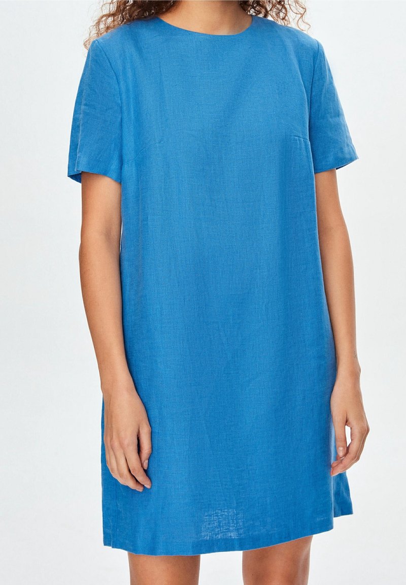 Vestido corto de lino azul con escote redondo, mangas cortas y un corte relajado, que presenta una textura suave y un diseño minimalista.