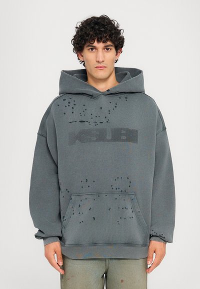 Sudadera gris de gran tamaño con un acabado texturizado, bolsillo frontal y logo de Ksubi. Presenta detalles desgastados dispersos y una capucha grande.