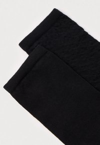 Fekete lábszárvédők texturált kötött mintával, sima felülettel és bordázott szegéllyel. Puha, rugalmas anyagból készült a kényelem érdekében.