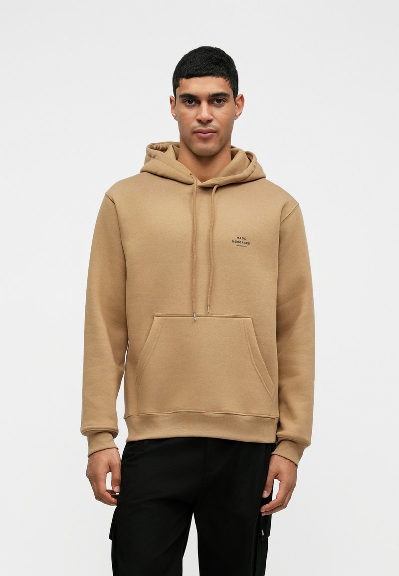 Μαύρη φούτερ με κουκούλα από μείγμα βαμβακιού. Διαθέτει μπροστινή τσέπη καγκουρό, ριγωτές μανσέτες και μικρή εκτύπωση λογότυπου στο στήθος.