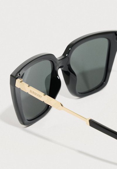 Czarne plastikowe okulary przeciwsłoneczne z szarymi soczewkami, o odważnych kwadratowych oprawkach i z�łotych metalowych akcentach na zausznikach, oznakowane marką "Burberry".