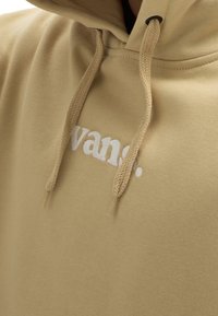 Felpa con cappuccio color sabbia dal tessuto morbido, con un logo bianco ricamato. Include cordoncini intrecciati e un design dalla vestibilità comoda.