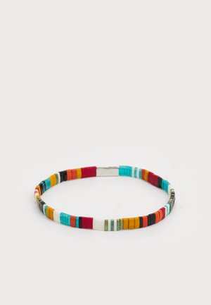 Pulsera de cuentas multicolores con una mezcla de cuentas turquesas, rojas, blancas, negras y amarillas, con un cierre de plata y textura suave.