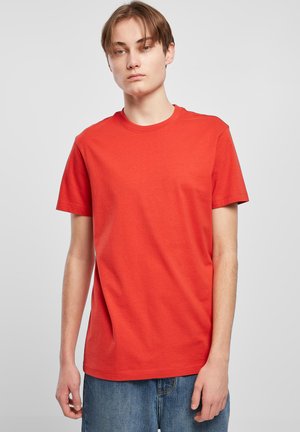 Rotes Baumwoll-T-Shirt mit kurzen Ärmeln und rundem Halsausschnitt. Der Stoff wirkt glatt und gleichmäßig, ohne sichtbare Muster oder Akzente.
