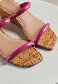 Sandaletter med kilehæl, korkplatform, nude læderfodbed og blanke pink plastikremme. Firkantet tådesign med en tekstureret overflade.