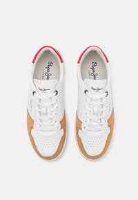 Baskets en cuir blanc et beige avec des accents rouges au niveau des talons, lacets blancs, zone perforée sur les orteils, et logos "Pepe Jeans London" sur les languettes et les côtés.