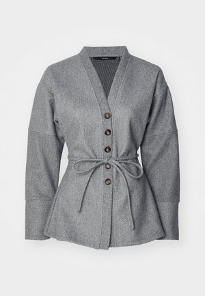 Jachetă gri în cutie cu decolteu în V, mâneci lungi, talie legată și șase nasturi maro. Material texturat moale cu o siluetă bine definită.