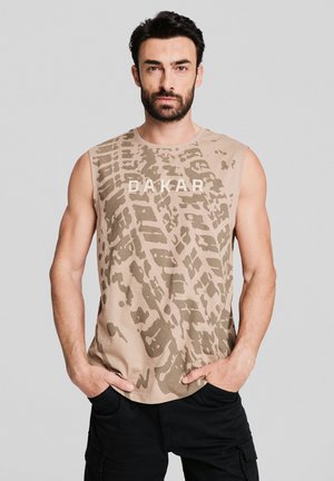 Beżowa koszulka bez rękawów z ciemno-brązowym wzorem abstrakcyjnym i napisem "DAKAR" w białym kolorze. Miękka tkanina i luźny krój.