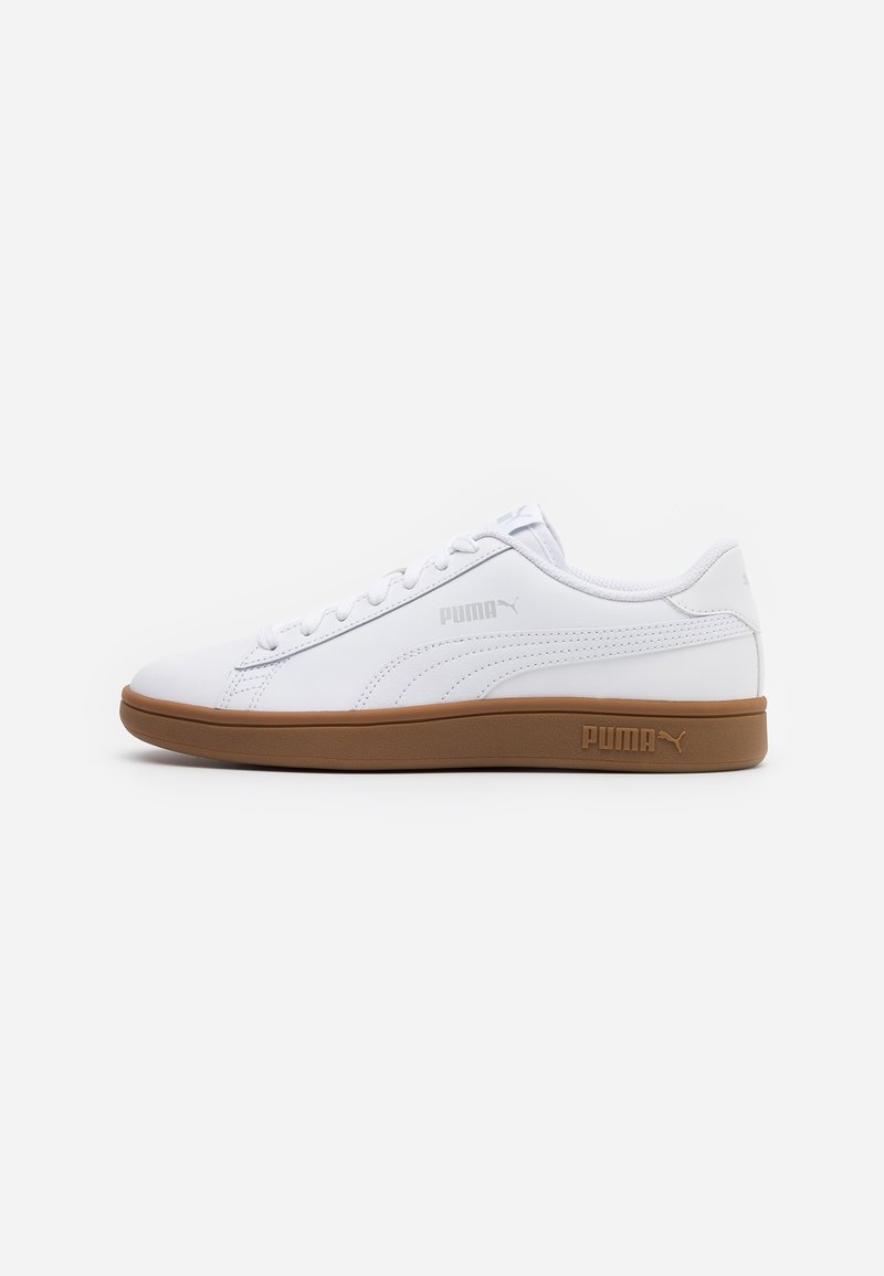 Sneaker blanc Puma basse avec semelle marron, fermeture à lacets à l'avant, logo Puma sur le côté et la semelle, présenté sur fond blanc.