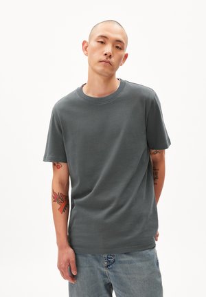 Gray cotton t-shirt with a round neck and short sleeves, worn with light blue denim jeans. Features smooth texture and casual fit.