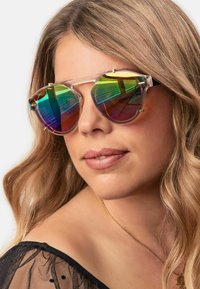 A pair of oversized, octagonal sunglasses with a transparent frame and gradient rainbow lenses, featuring gold accents on the hinges.