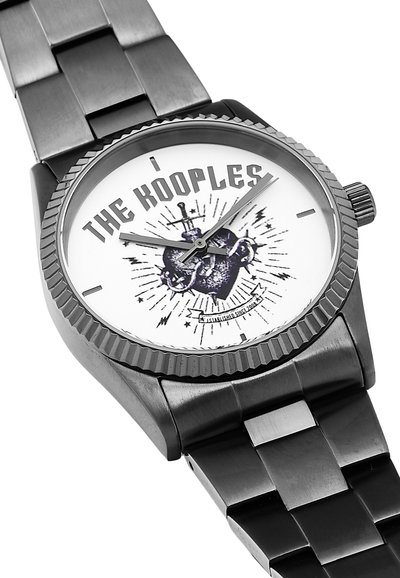 Reloj de acero inoxidable negro con una esfera blanca redonda. Presenta un texto negro audaz, un gráfico decorativo y manecillas de hora/minuto en plateado. Bisel texturizado.