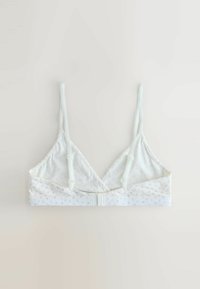 Bralet din țesătură albă moale, cu bretele subțiri ajustabile și un model floral mic, roz, pe banda de jos, așezat pe un fundal neutru.