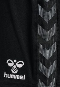 Zwarte sportshorts met een gestructureerd ontwerp, voorzien van een grijze chevronpatroon langs de zijkant en een wit logo van Hummel.