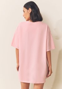 Roze oversized t-shirt gemaakt van zacht katoen. Heeft korte mouwen, een ronde hals en een losse pasvorm met een gladde textuur.