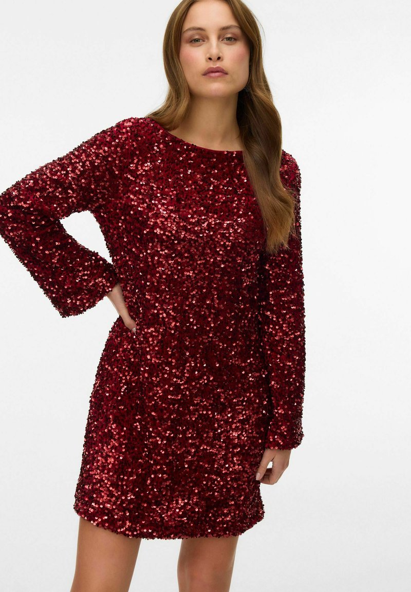 Vestido rojo de lentejuelas, de manga larga, con una longitud por encima de la rodilla. Textura de lentejuelas reflectante cubre toda la tela, con un escote redondeado.