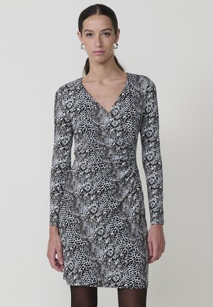 Vestido envolvente de estampado en blanco y negro con mangas largas, escote en V y forma ajustada. Presenta una mezcla de estampados abstractos y de animales.