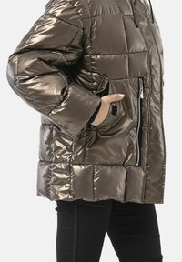 Gewatteerd metallic bruin donzen jack met een ritsvak aan de voorkant, hoge kraag en zwarte accenten; heeft een vierkante vorm en een doorgestikt ontwerp.