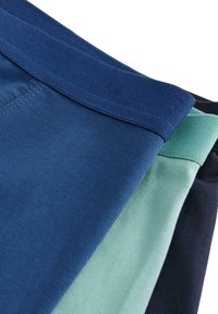 Kortsbyxor i marinblått, ljus teal och mörk marinblå, med elastiska midjeband och släta texturer. Varje shorts har en enhetlig, enkel design.