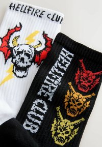 Sort-hvide sokker med et kraniegrafik med horn, lyn og teksten "HELLFIRE CLUB". Den sorte sok viser farvede kranier.