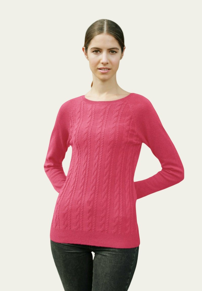 Pull en tricot cablé fuchsia à manches longues, col rond et ourlet côtelé, associé à un jean foncé. Texture lisse, motif de point uniforme.