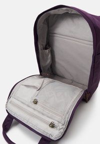 Purple fabric backpack with a gray interior. Features include multiple compartments, a mesh pocket, and dual zipper closures.