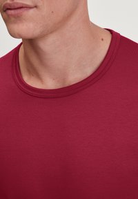 Bordeaux crew-neck t-shirt gemaakt van soepel katoen. Kenmerkt zich door een eenvoudig design met een geribbelde halslijn en zonder zichtbare patronen of logo's.