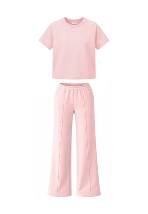 Top corto rosa chiaro a maniche corte abbinato a pantaloni ampi a vita alta con fascia elastica in vita e dettagli cuciture anteriori.