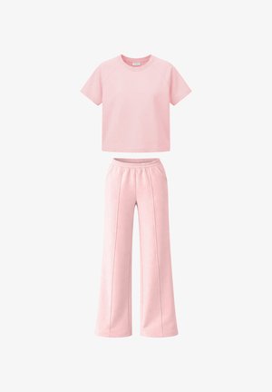 Top corto rosa chiaro a maniche corte abbinato a pantaloni ampi a vita alta con fascia elastica in vita e dettagli cuciture anteriori.