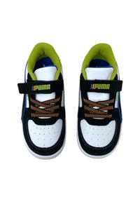 Zapatillas en blanco y negro con forro verde, cordones naranjas y una correa de Velcro que presenta el logo de Puma. Tejido texturizado y detalle de puntera perforada.